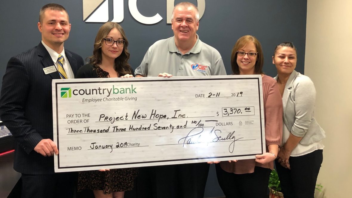 Group photo of Country Bank staff and a representative from Project New Hope for a check presentation.