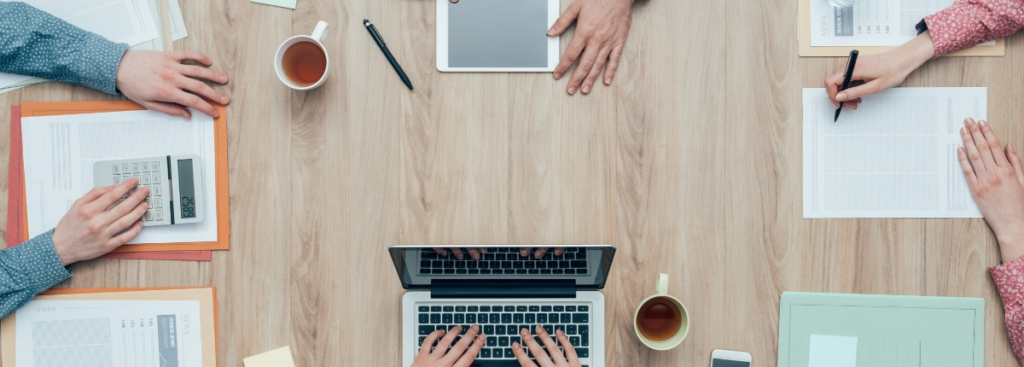Image of individuals hands around a table