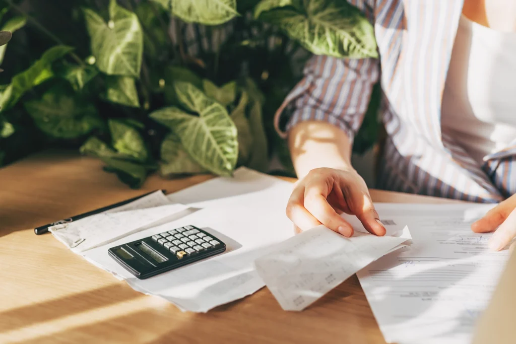 Country-Bank-person-at-desk-looking-at-papers-calculator-and-pen-and-paper