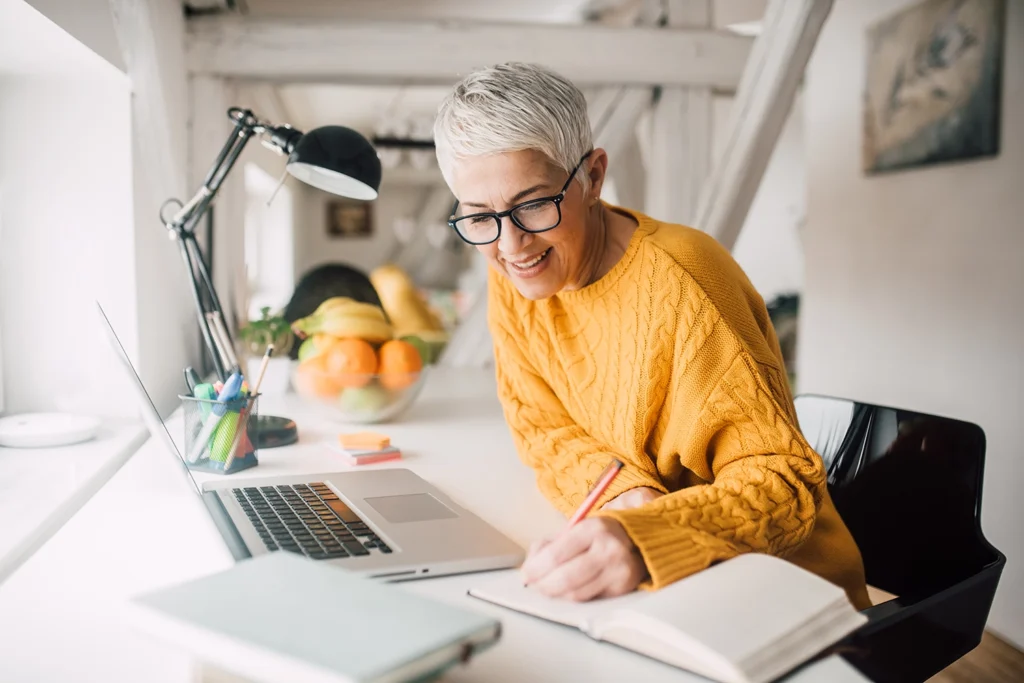 Country-Bank-professional-woman-in-glasses-and-orange-sweater-writing-on-a-notebook