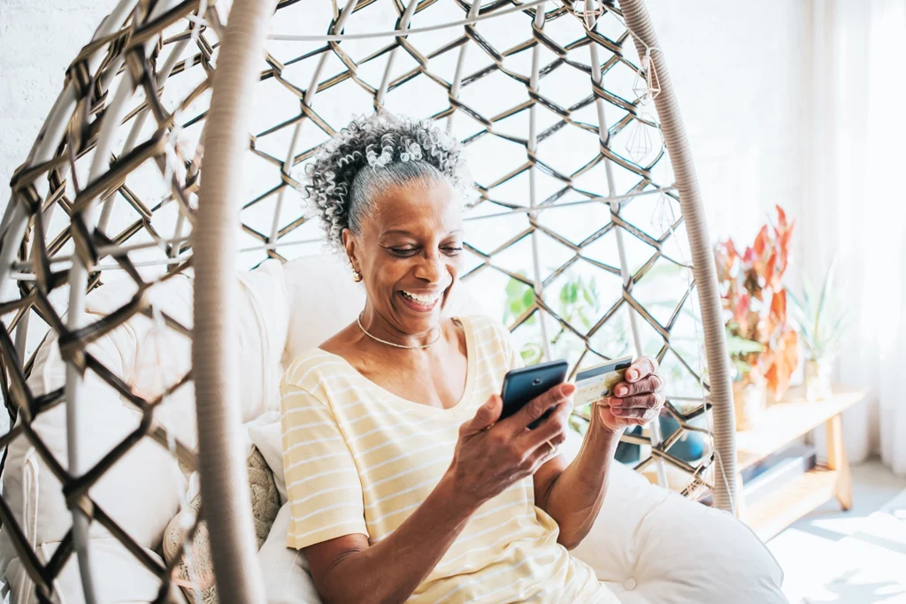 Country-Bank-senior-woman-in-bamboo-swing-chair-opening-checking-account-online