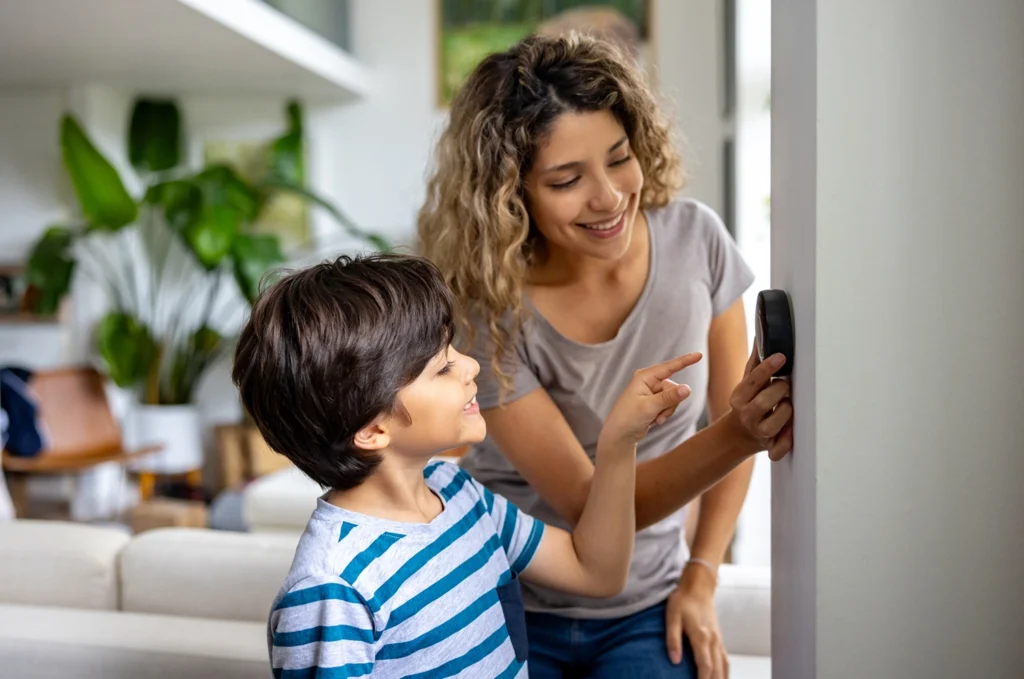 Country-Bank-woman-and-young-son-adjusting-the-thermostat-in-their-home