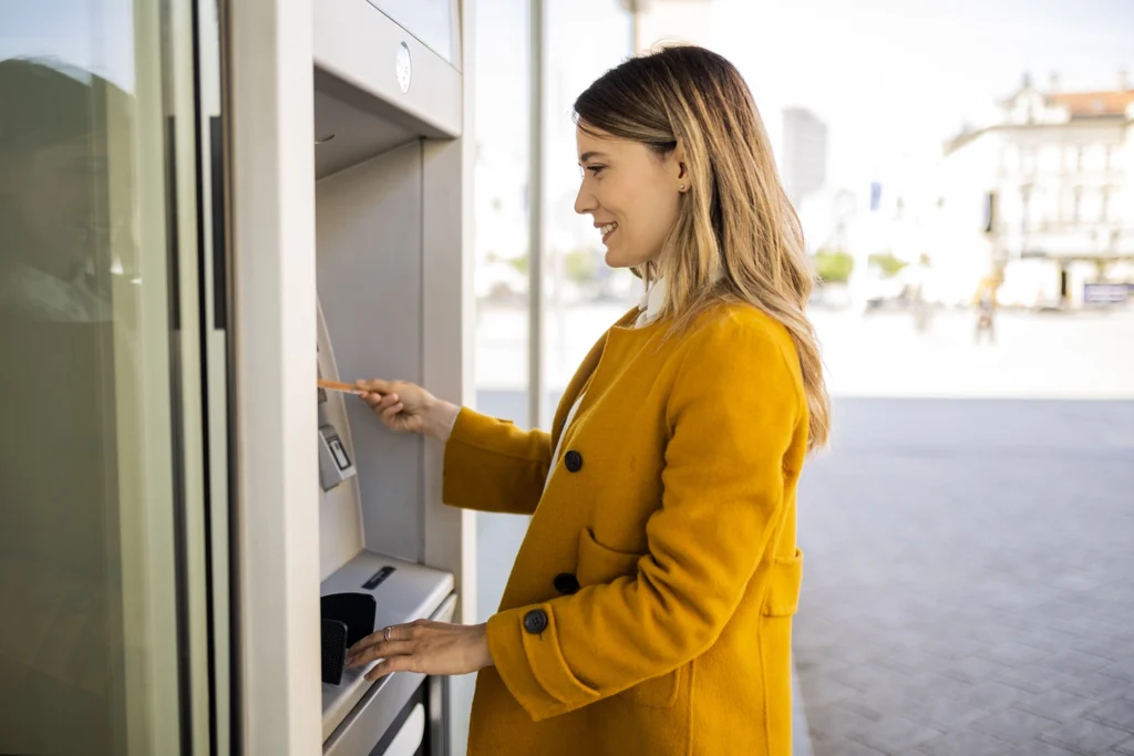 Country-Bank-woman-inserts-bank-card-into-ATM-machine