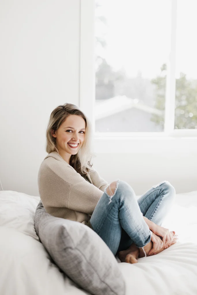 Country-Bank-young-smiling-woman-sitting-cross-legged-on-white-couch-wearing-jeans